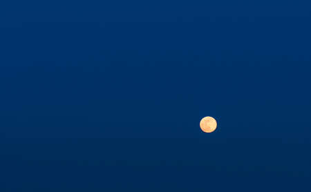 Full yellow moon on the blue sky backgroundの写真素材