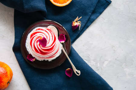 Rose water blood orange and vanilla ice-cream served on a plate. White stone background.