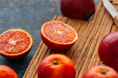 Whole and sliced fresh ripe  blood oranges on a wooden board. Close upの写真素材