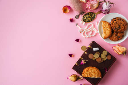 Flat lay of femenine things cookies coffee pearls flowers on a pknk background. Top view.の写真素材