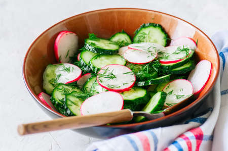 Healthy salad from fresh vegetables. Close up of cucumber and radish salad bowl. Healthy or summer food food concept.の写真素材
