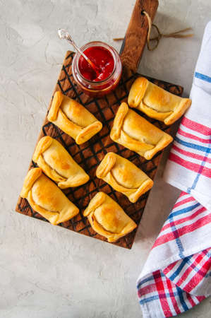 Top view of chilean empanadas on a wooden plate with ketchup. White stone background.の写真素材