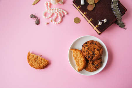 Flat lay of femenine things cookies coffee pearls flowers on a pknk background. Top view.の写真素材