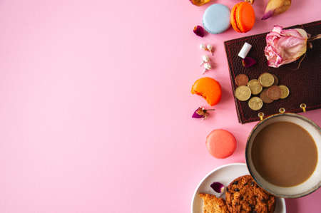 Flat lay of femenine things cookies coffee pearls flowers on a pknk background. Top view.の写真素材
