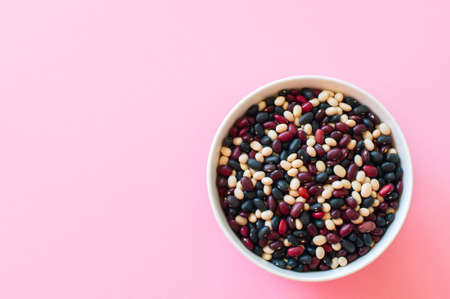 Mix of dry beans in a white bowl on a pink background. Top view and copy space.の写真素材