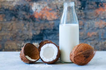 Whole coconuts and coconut products as milk and powder. White stone background.の写真素材