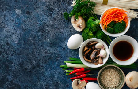 Ingredients of asian cuisine noodles eggs vegetables spices sauce herbs. Flat lay top viewの写真素材