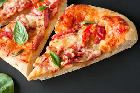 Three slices salami mozarella pizza black background. Top view flat lay copy space.の写真素材