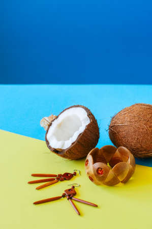 Summer vacation, eco and casual style concept. Fashionable wooden wristband and earrings coconuts on duotone background.の写真素材