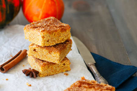 Pumpkin cornmeal bars with spices on a wooden background. Close up.の写真素材