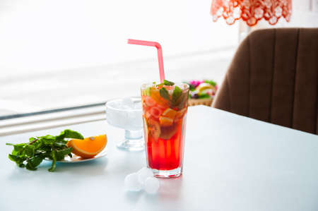 Glass of fresh fruit lemonade with mint. Cold beverage on a light blue background. Close up.の写真素材