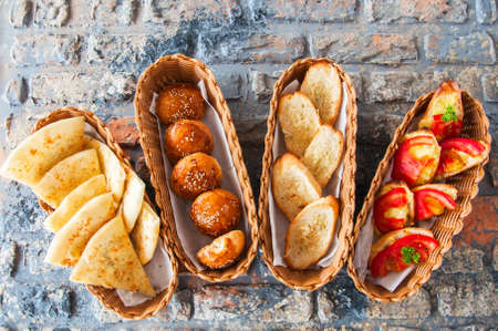 Variety bread snacks in a basket. Burger buns, focaccia, croutons and bruschetta. Top view.の写真素材