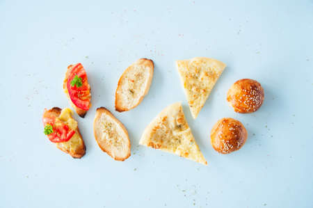 Variety bread snacks on a light background. Burger buns, focaccia, croutons and bruschetta. Top view.の写真素材