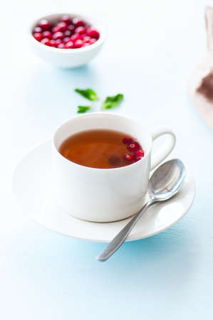 Tea with cranberry on a light blue background. Close up.の写真素材