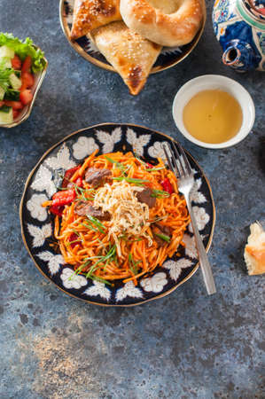 Oriental and middle eastern food concept. Lagman, samsa, flatbread, green tea on blue background.の写真素材