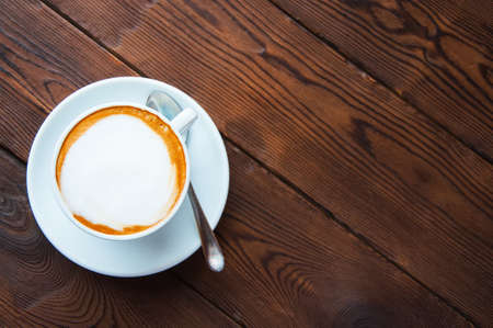 One cup of coffee on a wooden background. Top view. Copy space.の写真素材