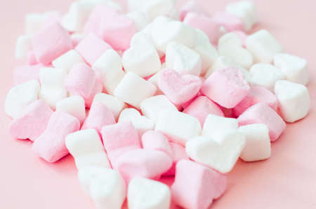 Pink fluffy heart shaped marshmallow background. Close up.