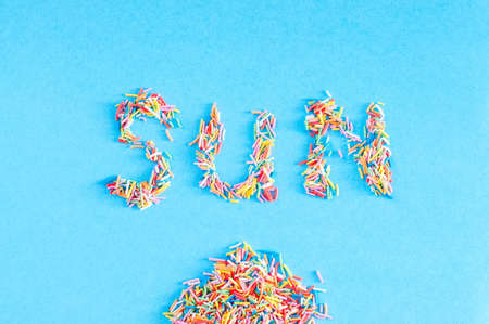 Colorful pastry sprinkes background. Sun - word inscription.