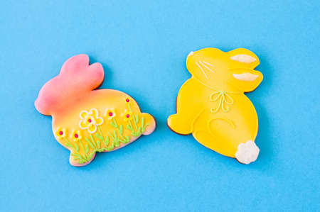 Easter background concept. Colored bunnies on blue background. Top view.