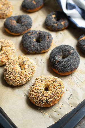 Freshly baked sesame and poppy seeded bagels. Close up.