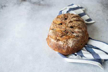 Homemade artisanal sourdough bread with raisins and ruy flour. Healthy home baking concept.