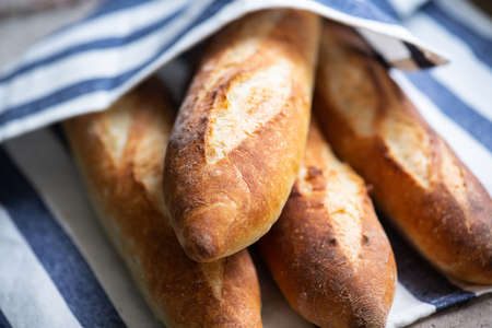 Batch of freshly baked baguettes on a napkin. Close up.の写真素材
