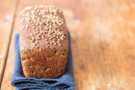 Famous russian rye sourdough bread - Borodinskiy with cardamom and malt on a wooden background. Close up.の写真素材