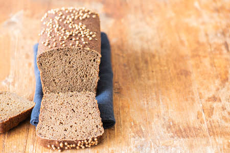 Famous russian rye sourdough bread - Borodinskiy with cardamom and malt on a wooden background, cutted. Close up.の写真素材