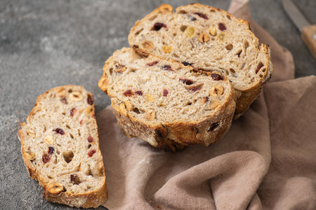 Halved sourdough fruit bread with dried apricots, cranberries and hazelnuts.の写真素材