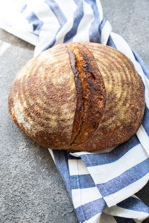 Rye sourdough bread on a napkin on a gray background. Artisanal bread concept. Overhead view.の写真素材