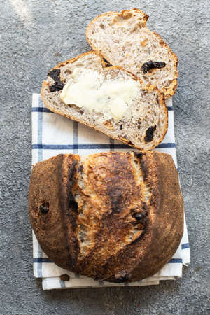 Freshly baked sliced sourdough bread with dried apricots and prunes on a gray background. Close up.