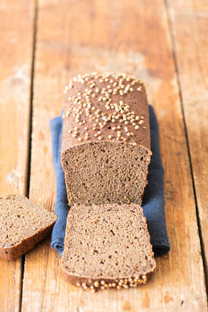 Famous russian rye sourdough bread - Borodinskiy with cardamom and malt on a wooden background. Close up.の写真素材