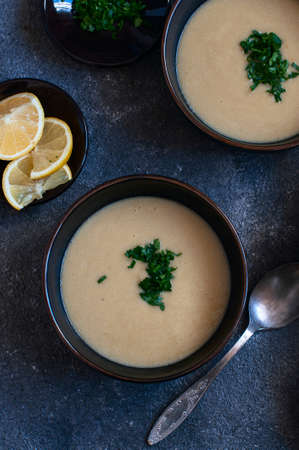 Lentil soup puree with herbs in a black bowls on a gray background.の写真素材