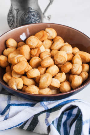 Shi - baursak, Kazakh national festive baking, small fried donuts in a bowl on a white background....