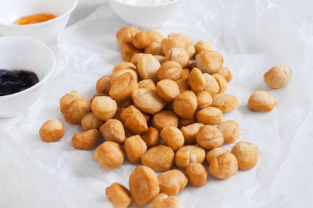 Shi-baursak, Kazakh traditional fried dounuts served on a parchment paper on a white background. Festive sweet baking.の写真素材