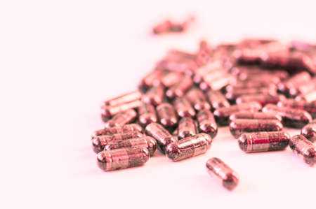 Black capsules on a pink background, Conceptual image of depression or stress.の写真素材