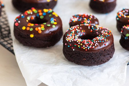 Chocolate baked donuts with chocolate frosting and sprinkles.の写真素材