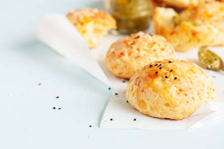 Homemade small cheese dinner rolls with sesame seeds on a baking paper.の写真素材