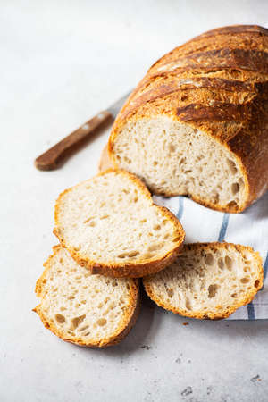 Homemade artisanal sliced sourdough bread on a wooden background. Healthy home baking concept.