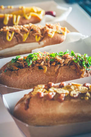 Freshly prepared assorted hotdogs in a paper box. Food delivery or take away food concept.の写真素材