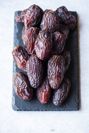 Medjoul dates on a black slate board on a gray background.の写真素材