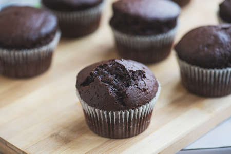 Chocolate muffins on a wooden board.の写真素材