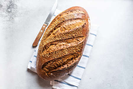 Top view of artisanal sesame seed bread on a napkin. Gray background.の写真素材