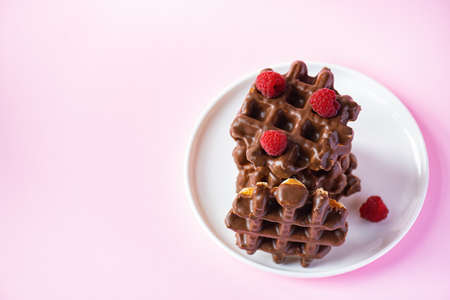 Stack of chocolate waffles with berries. Close up and pink background.の写真素材