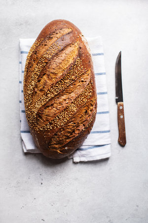Top view of artisanal sesame seed bread on a napkin. gray background.の写真素材