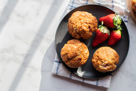 Strawberry muffins served in a plate on a marble background. Top view and copy space.の写真素材