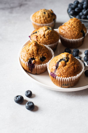 Blueberry muffins served on a white plate on a marble background.の写真素材