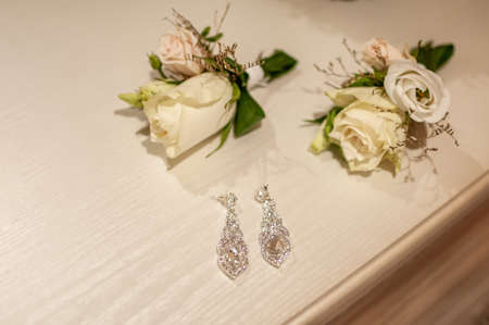 Earrings and two flower buds on the table