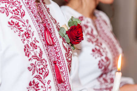 Red rose boutonniere on the embroidered shirtの写真素材