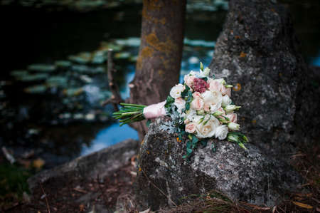 Wedding flower bouquet lies on the rockの写真素材